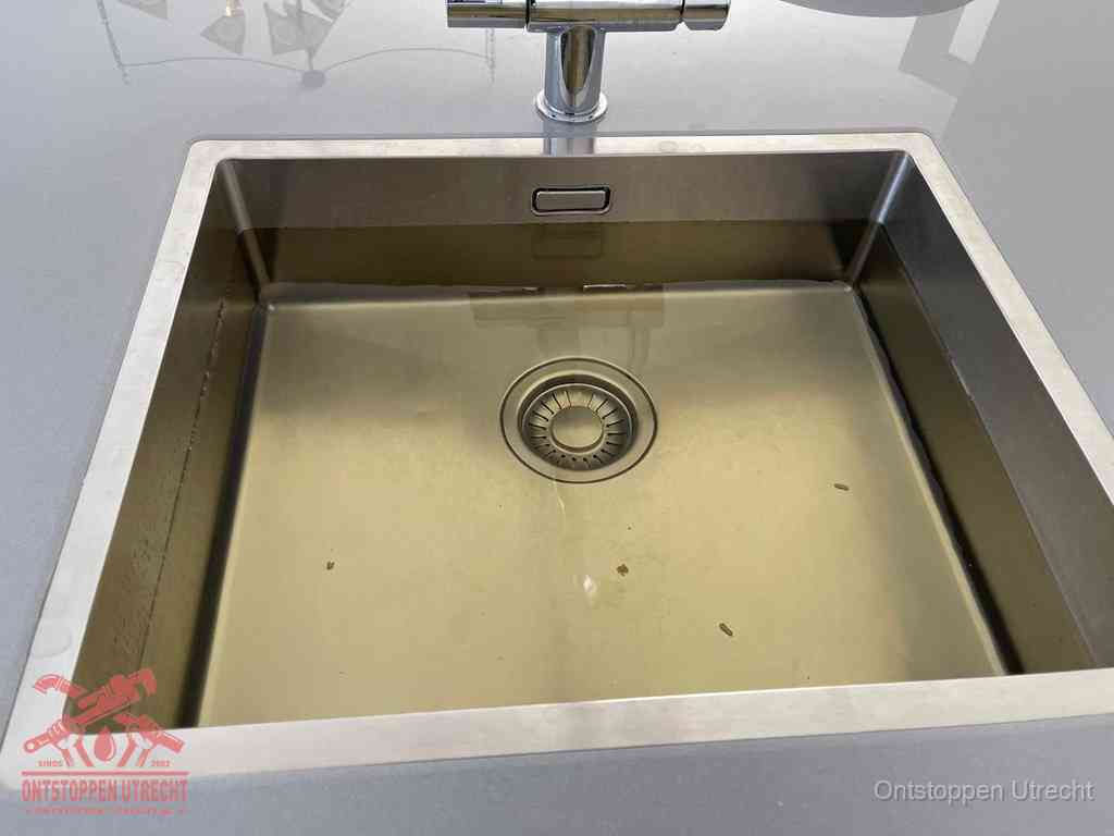 Stilstaand water in een rvs spoelbak dat niet wegloopt, een duidelijk signaal van een gootsteenverstopping in Utrecht