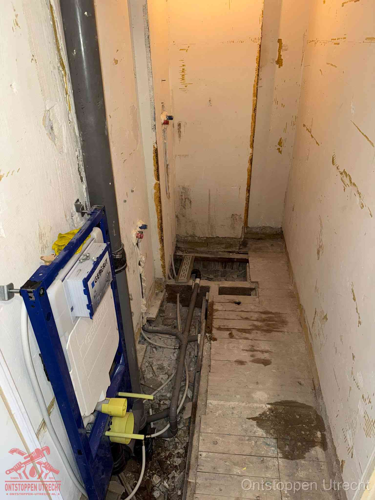 Een opgebroken toiletruimte tijdens renovatie met een Geberit inbouwreservoir en blootliggende oude afvoerleidingen, typisch voor oudere woningen in Utrecht